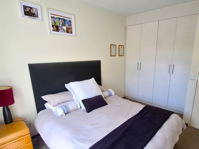 A functional bedroom featuring built-in cupboards and neutral wall finishes, providing a practical and comfortable living space.