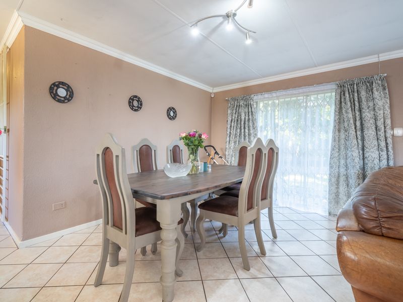A dining area featuring tiled flooring, crown molding, and a sliding glass door providing natural light and access to the exterior.