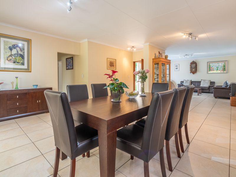 Spacious open-plan living and dining area featuring neutral tiled flooring and integrated air conditioning, providing a versatile layout for family living and entertaining.