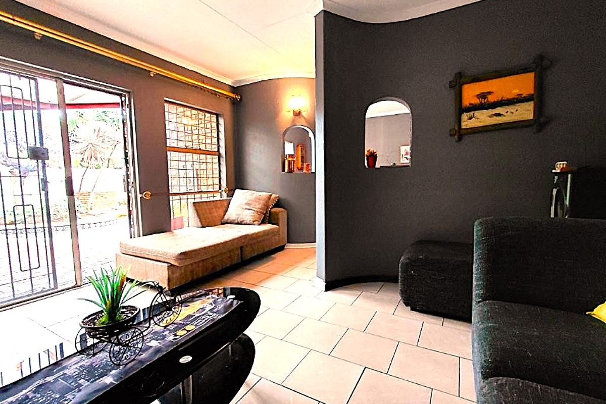 Living room featuring tiled flooring, a coved ceiling, and a sliding glass door with security gate providing access to the exterior.