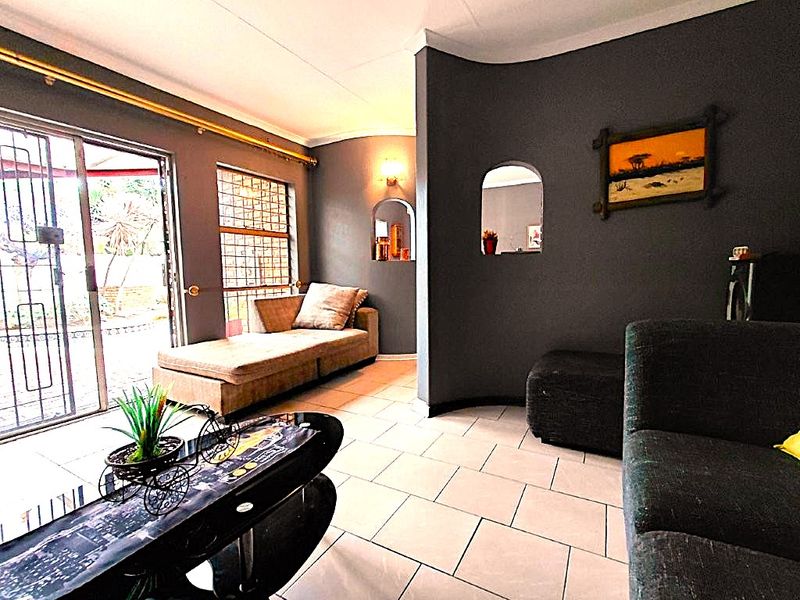 Living room featuring tiled flooring, a coved ceiling, and a sliding glass door with security gate providing access to the exterior.