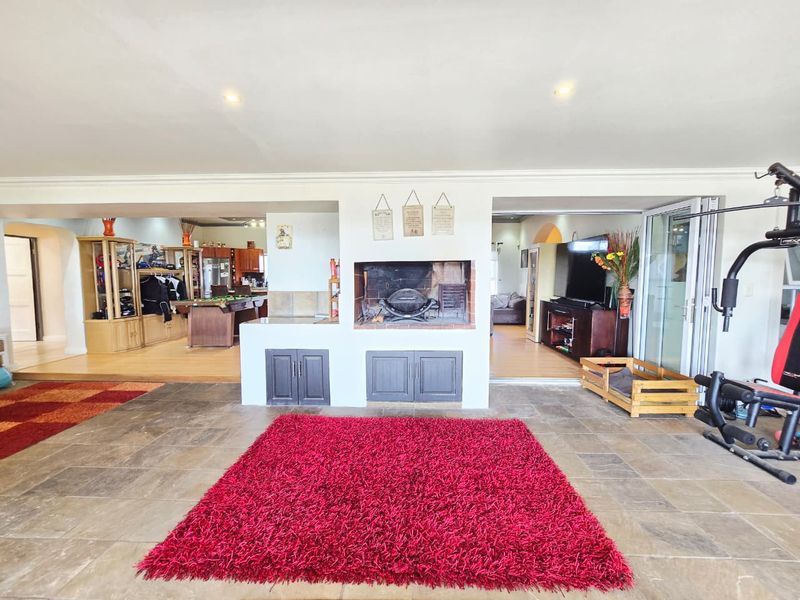 Spacious open-plan living area featuring a central built-in fireplace, tiled flooring, and seamless flow between multiple functional zones.