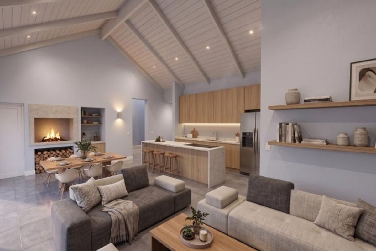 Spacious open-plan living area featuring a vaulted ceiling with exposed beams, a modern kitchen with island, and a cozy built-in fireplace.