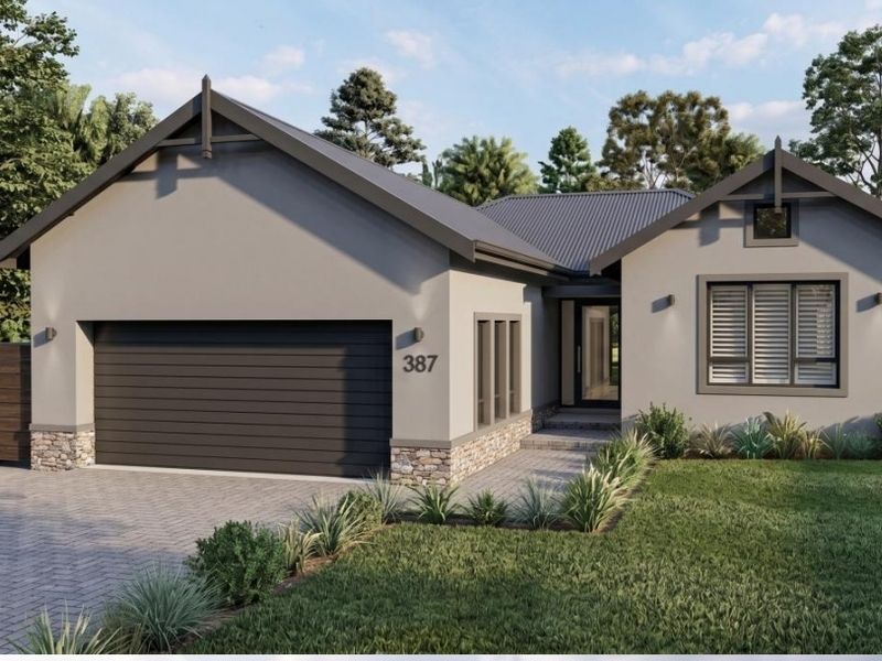 Modern single-story residential home featuring a double garage, stone-accented facade, paved driveway, and contemporary architectural styling.