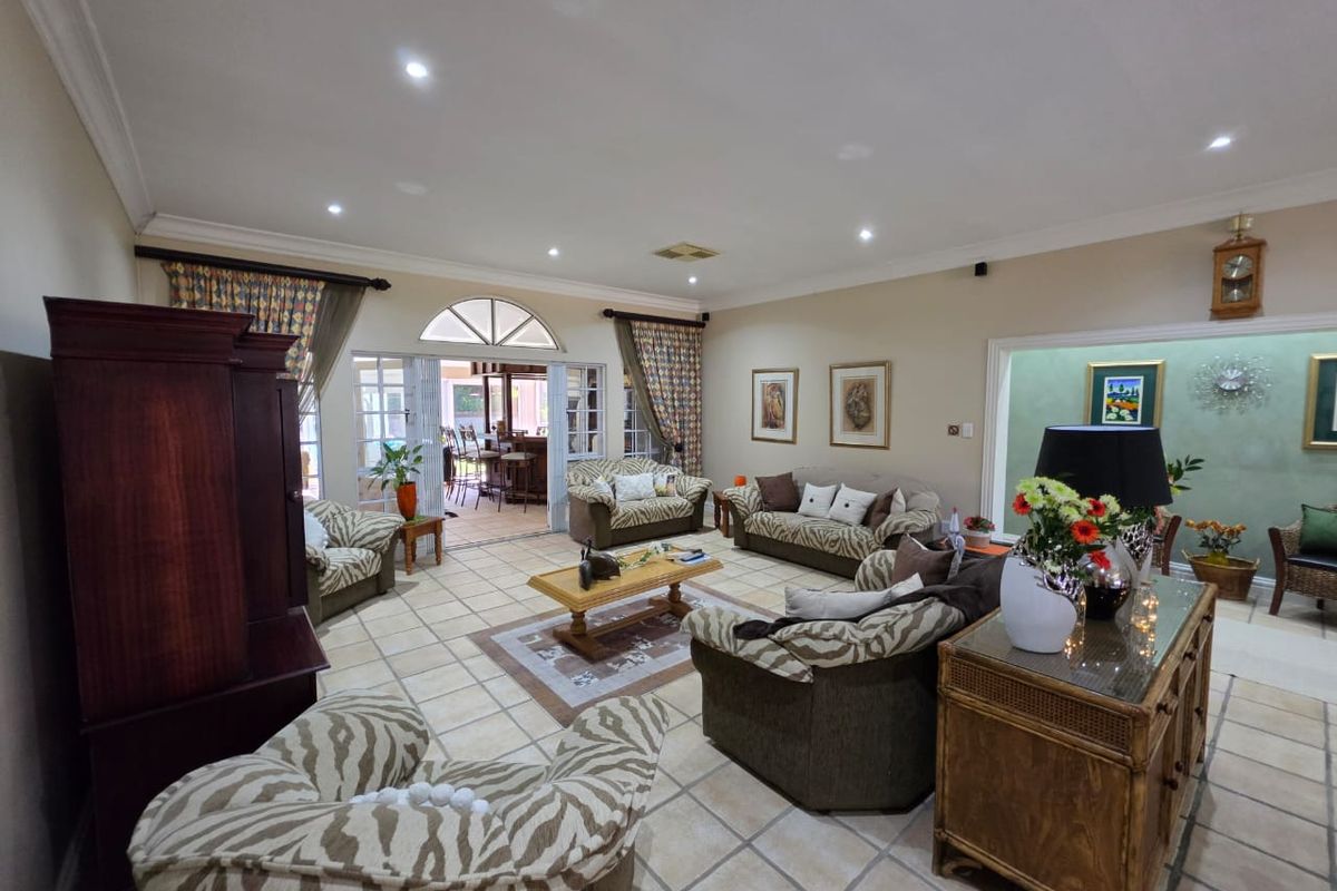Spacious living room featuring tiled flooring, recessed lighting, and large sliding glass doors providing access to an outdoor patio area.
