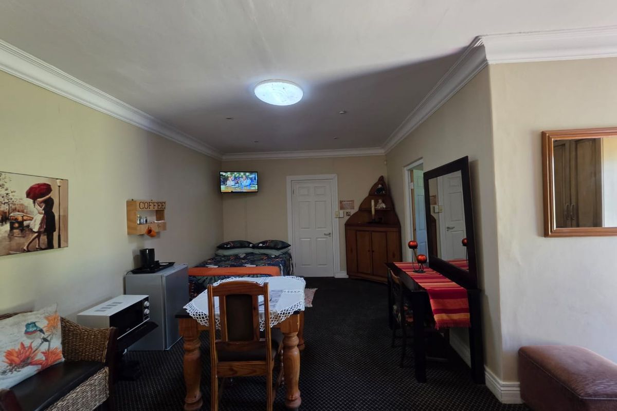 A bedroom featuring crown molding and recessed lighting, with visible wall cracks requiring maintenance.