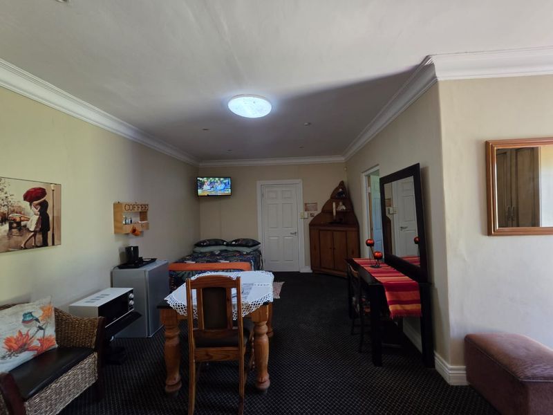 A bedroom featuring crown molding and recessed lighting, with visible wall cracks requiring maintenance.