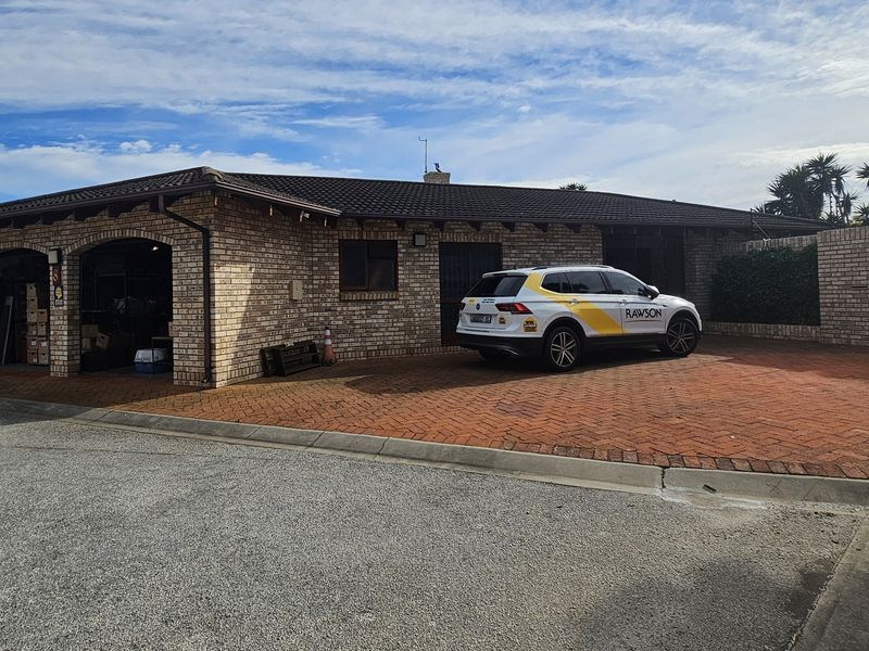 Front exterior view of a face brick house featuring a double garage and a paved driveway.