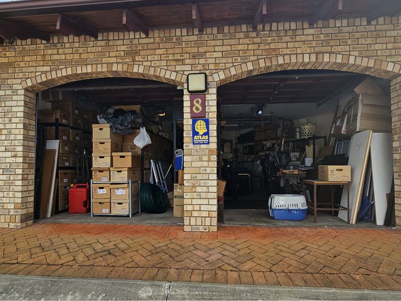 A double garage featuring a classic brick facade with arched openings and exposed timber rafters, providing ample storage space.
