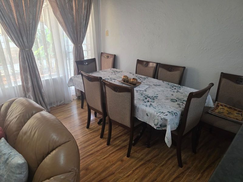 A dining area featuring laminate flooring and a large sliding glass door that provides natural light.