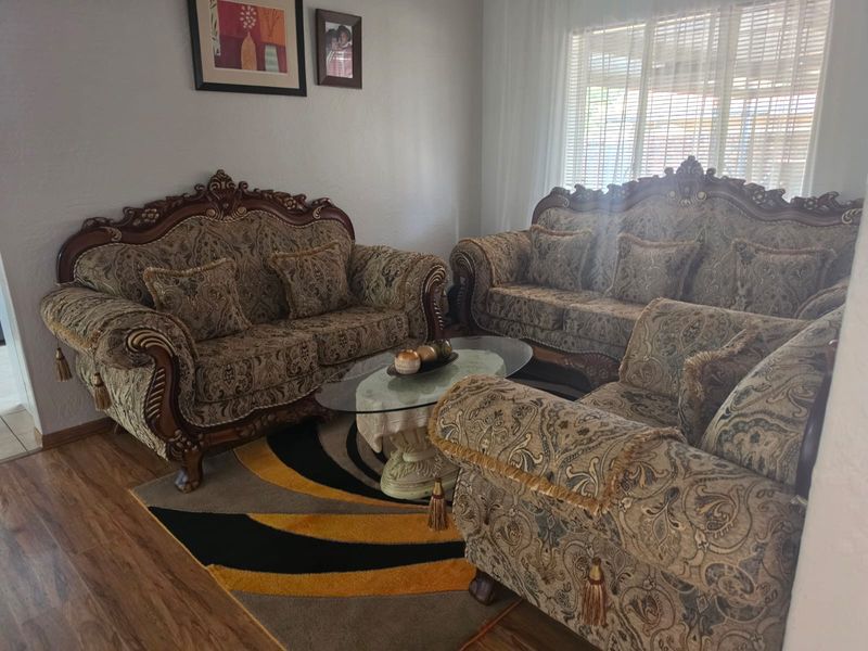 A comfortable living room featuring laminate flooring and natural light filtered through venetian blinds, providing a functional and inviting space.