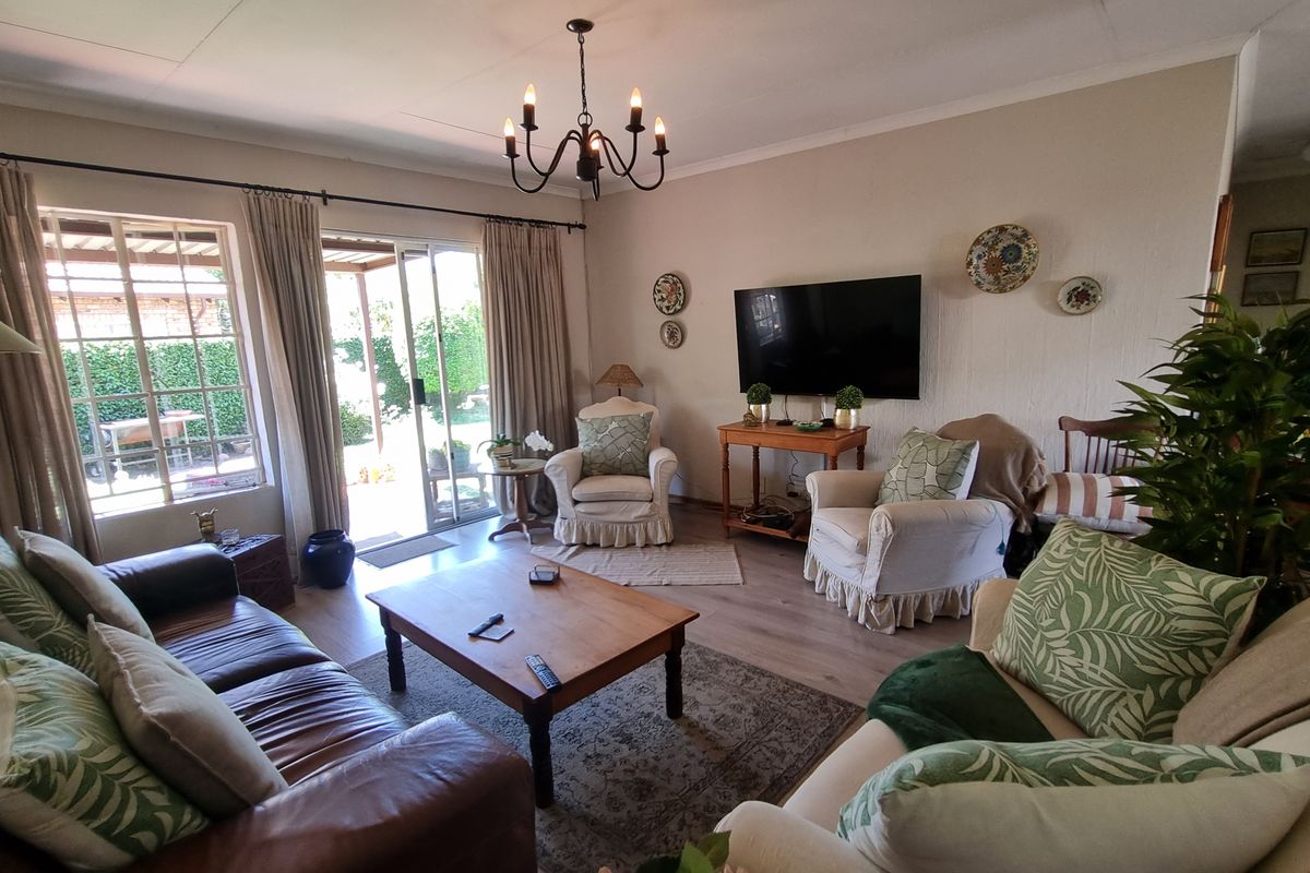 A comfortable living room featuring laminate flooring and a sliding glass door that provides direct access to the outdoor patio area.