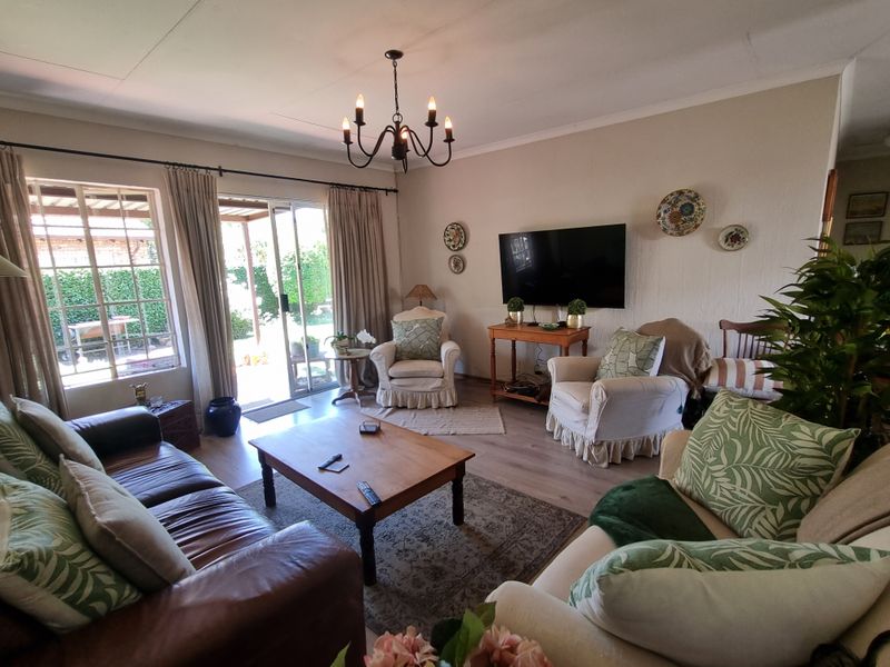 A comfortable living room featuring laminate flooring and a sliding glass door that provides direct access to the outdoor patio area.