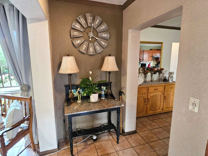 An entry area featuring tiled flooring and an archway leading into the kitchen and living spaces.