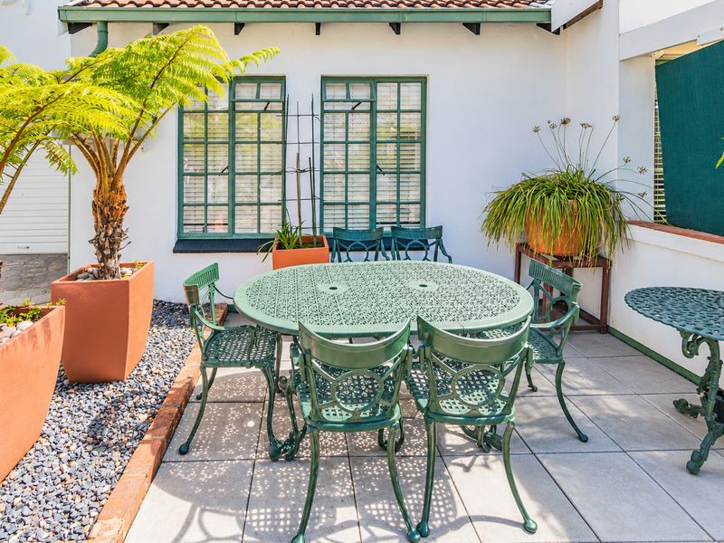 A well-maintained paved patio area featuring brick edging and multi-pane windows, providing a pleasant outdoor space for relaxation.