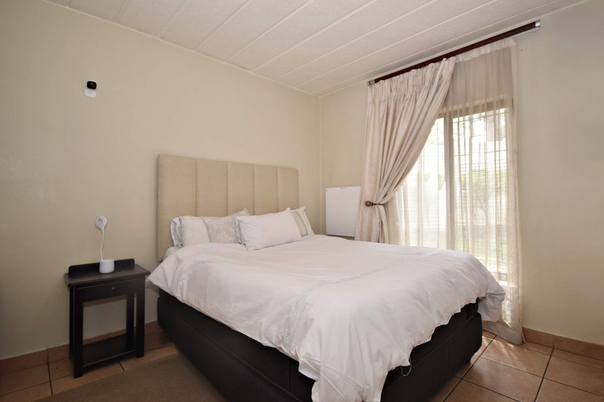 A bedroom featuring tiled flooring and a sliding glass door providing access to the exterior.