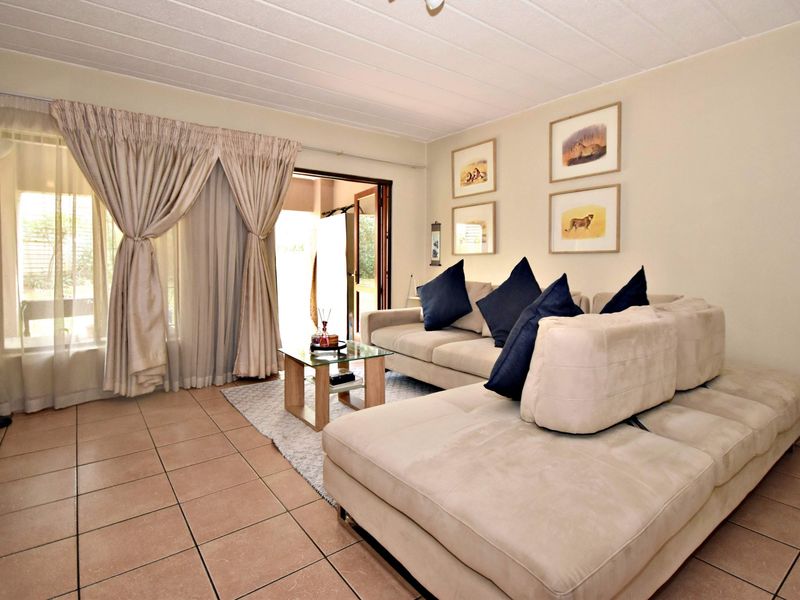 A comfortable living room featuring tiled flooring and a sliding glass door that provides access to the outdoor area.