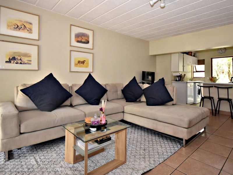 Open-plan living area featuring tiled flooring and a functional kitchen space with a breakfast counter.
