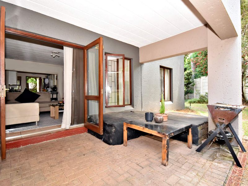 A covered brick-paved patio area providing direct access to the interior living space, featuring a sheltered outdoor area suitable for relaxation.