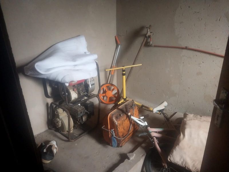 A small utility storage space featuring unfinished walls and exposed plumbing fixtures, suitable for conversion into a functional storage or laundry area.