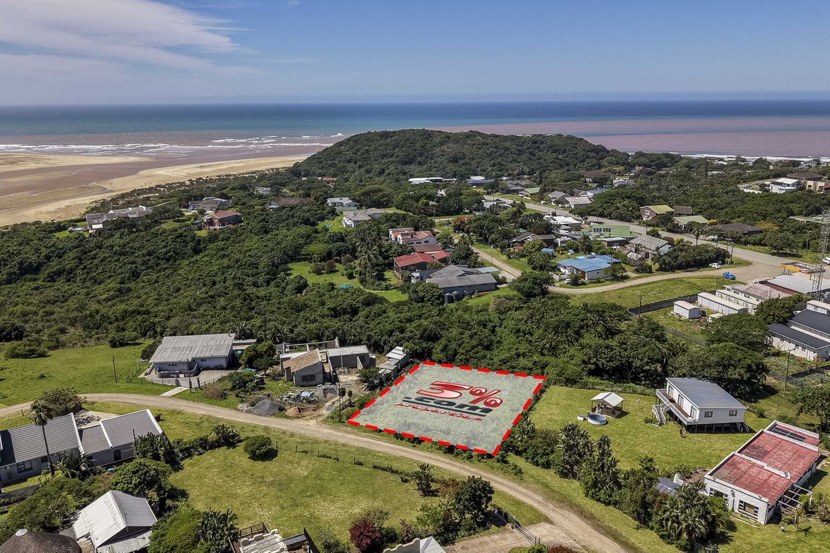 Aerial view of a vacant residential plot situated in a coastal neighborhood, offering proximity to the beach and surrounding natural landscape.