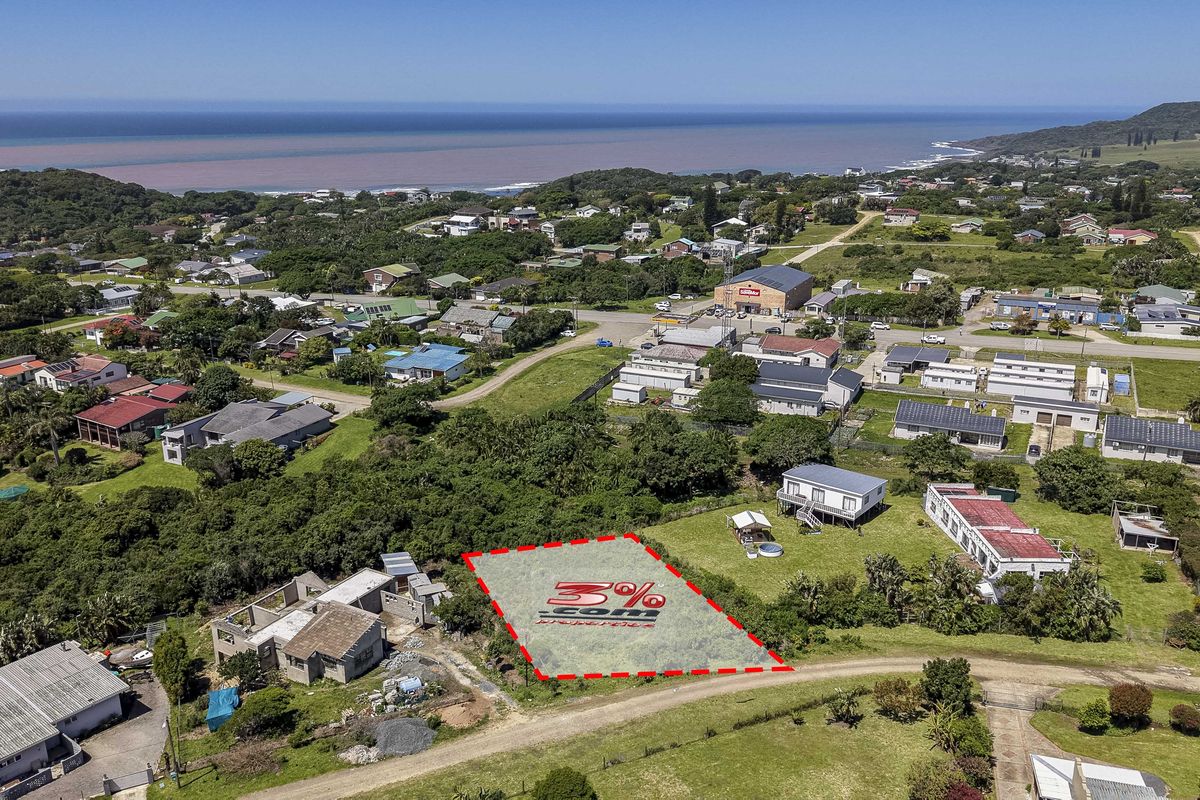 An aerial view of a vacant residential plot situated in a coastal neighborhood, highlighting the surrounding landscape and proximity to the ocean.