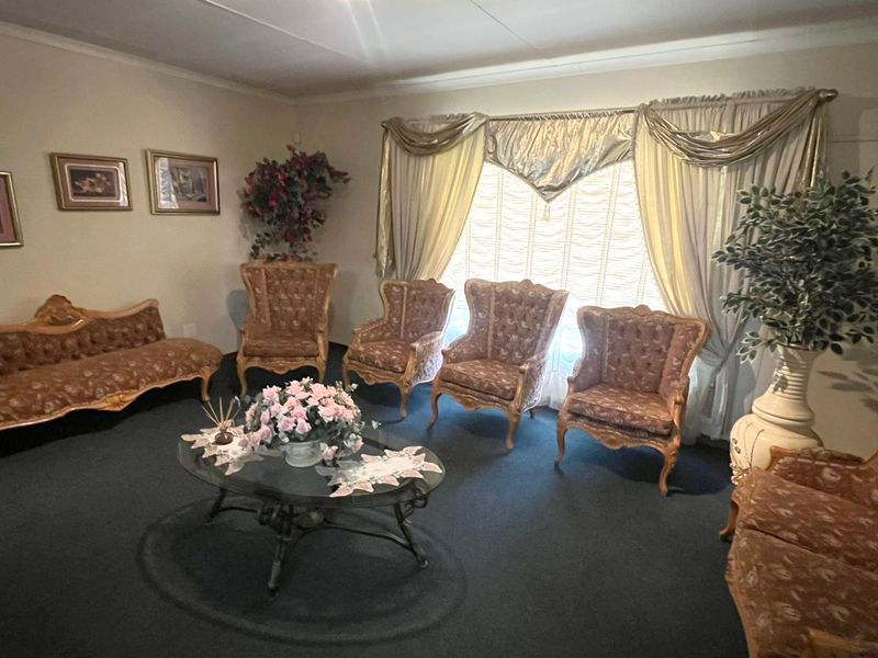 A traditional living room featuring coved ceilings and window treatments, offering a classic layout ready for modern updates.