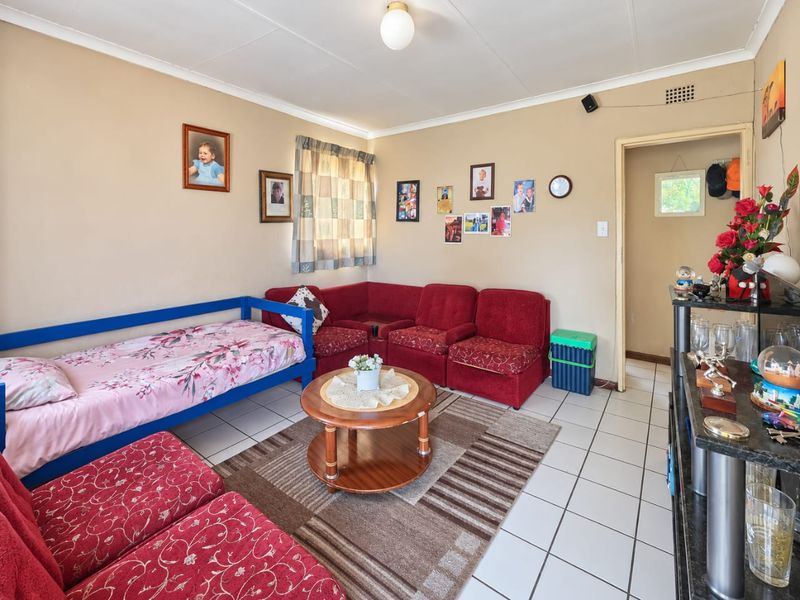 A functional living room featuring tiled flooring and neutral wall finishes, providing a versatile space for relaxation and daily living.