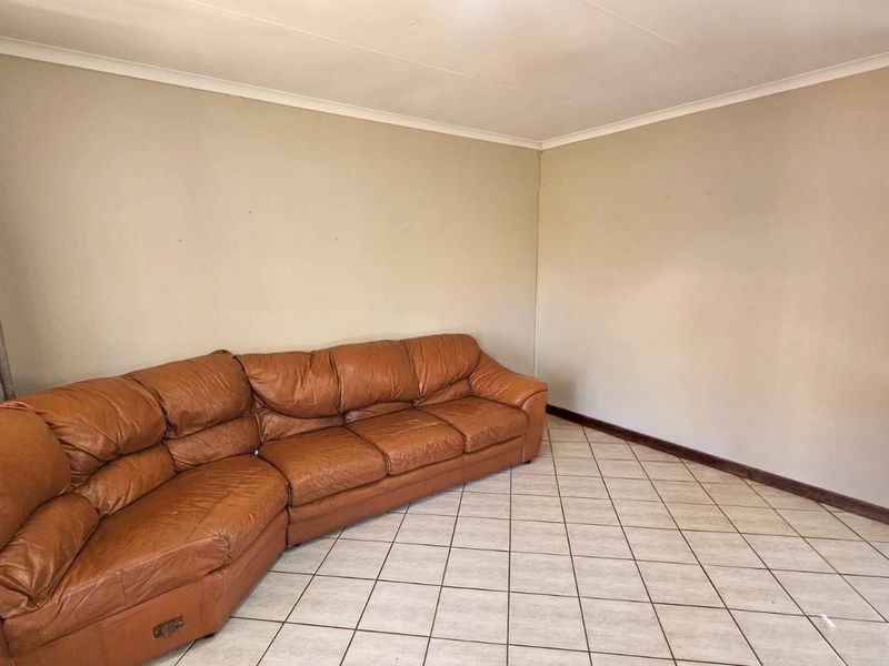 A living room featuring neutral wall tones and tiled flooring, providing a functional and versatile space for relaxation.