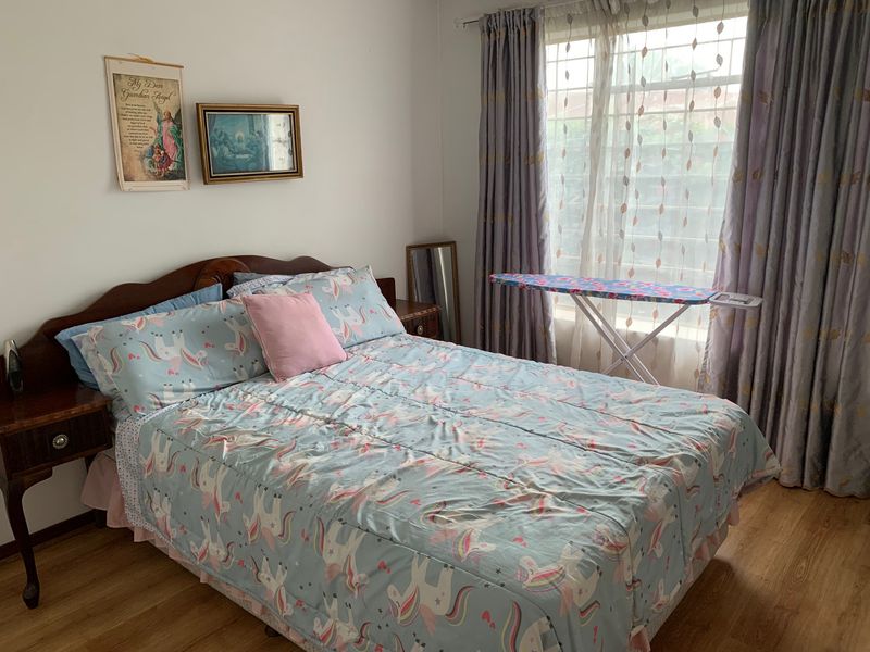 A bedroom featuring laminate flooring and window treatments, providing a functional space ready for personalization.
