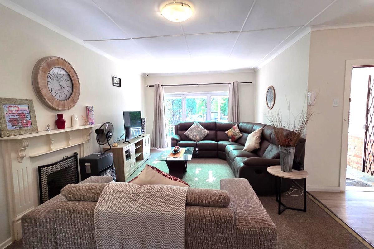 A comfortable living room featuring a fireplace with a mantelpiece and a security gate at the entrance.