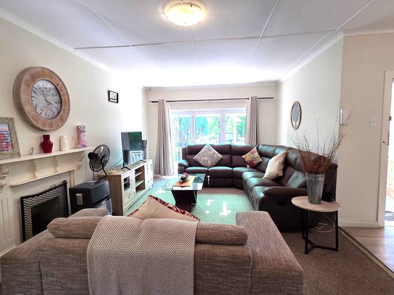 A comfortable living room featuring a fireplace with a mantelpiece and a security gate at the entrance.