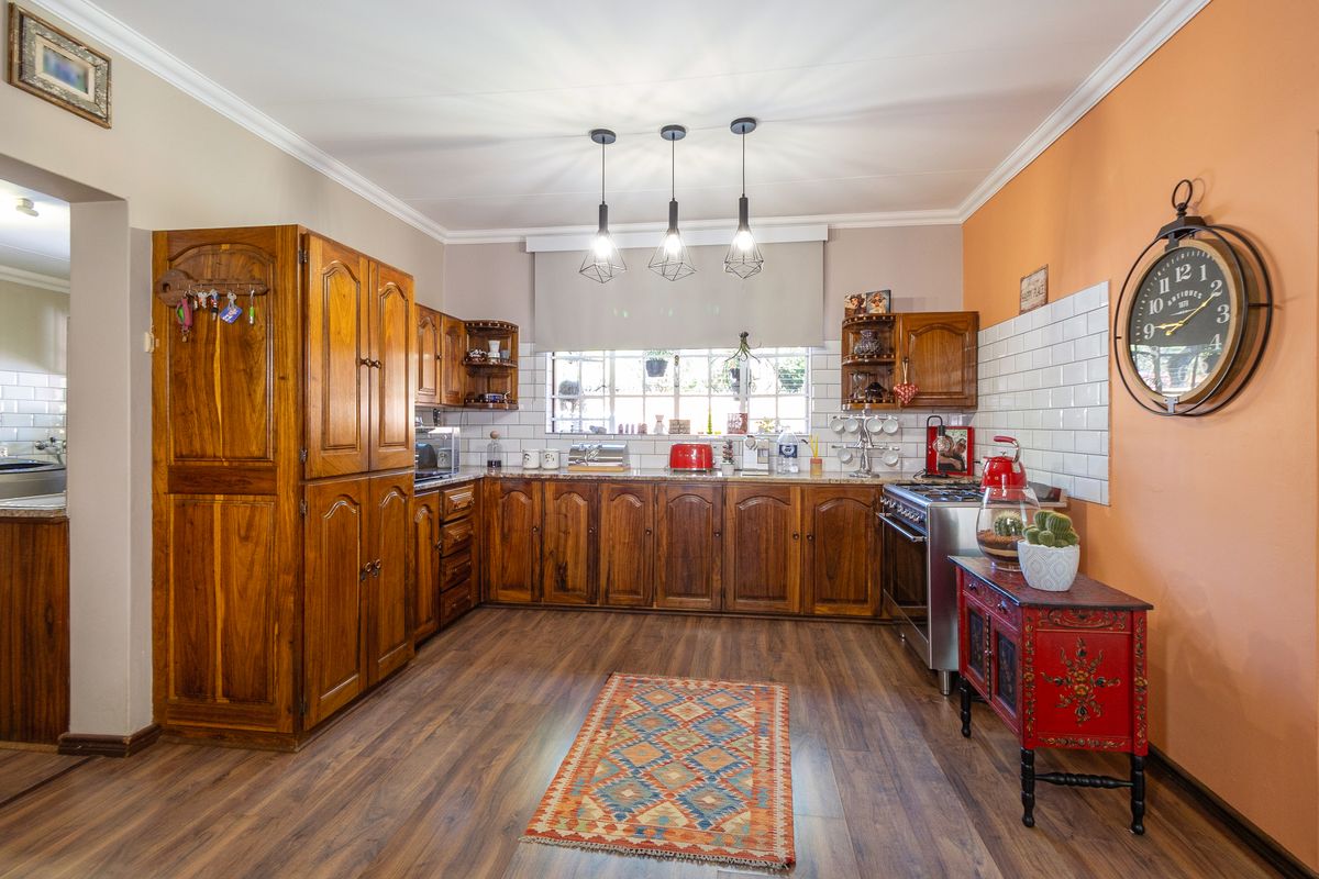 A functional kitchen featuring warm-toned wooden cabinetry, granite countertops, subway tile backsplash, and modern pendant lighting, offering a classic and inviting culinary space.