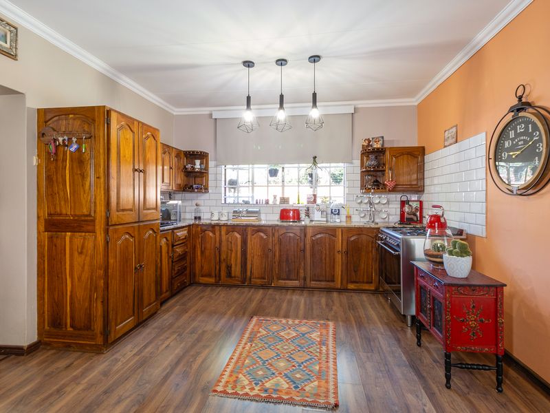A functional kitchen featuring warm-toned wooden cabinetry, granite countertops, subway tile backsplash, and modern pendant lighting, offering a classic and inviting culinary space.