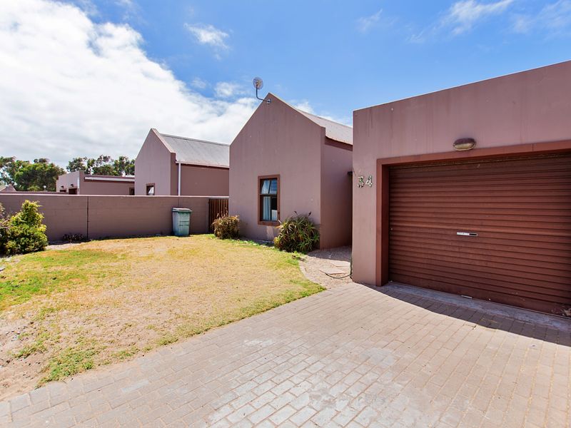 Front exterior view of the property featuring a paved driveway, single garage, and a small front garden area.