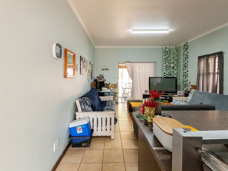 Open plan living area featuring tiled flooring and a sliding door leading to an outdoor space, providing a functional and connected layout.