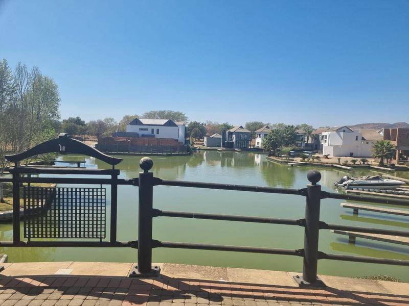 Scenic view overlooking a tranquil estate lagoon with private jetties and surrounding residential properties.