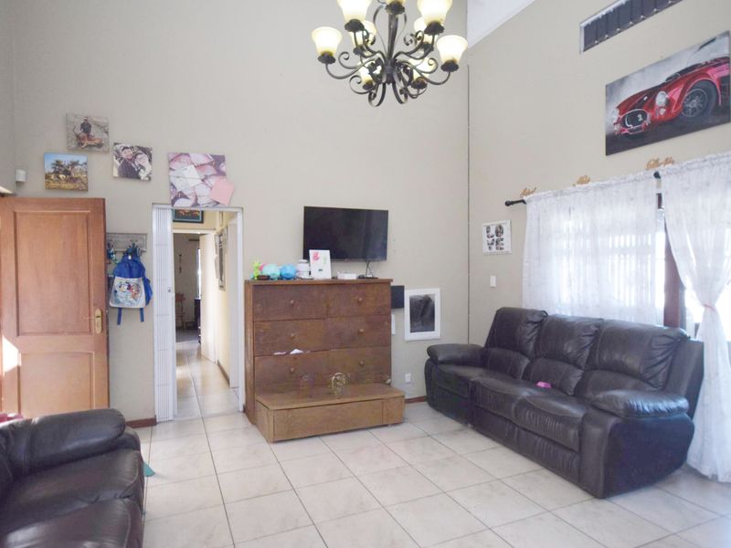 Spacious living room featuring high vaulted ceilings, ceramic tile flooring, and an integrated air conditioning unit.