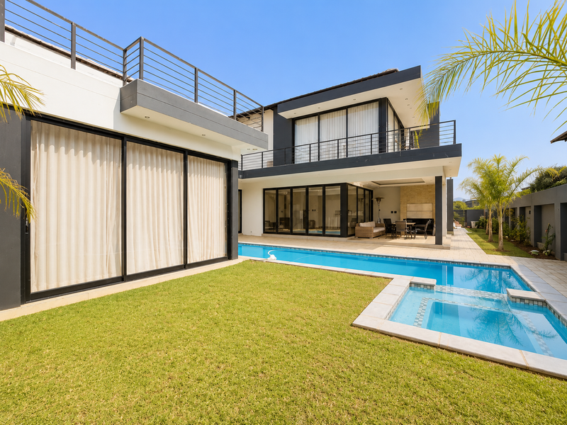 Modern double-story residence featuring a swimming pool, integrated spa, expansive sliding glass doors, and a spacious patio area perfect for outdoor entertaining.