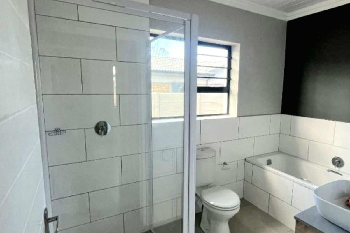 Modern bathroom featuring a glass-enclosed shower, built-in bathtub, vessel sink vanity, and contemporary subway tile finishes.