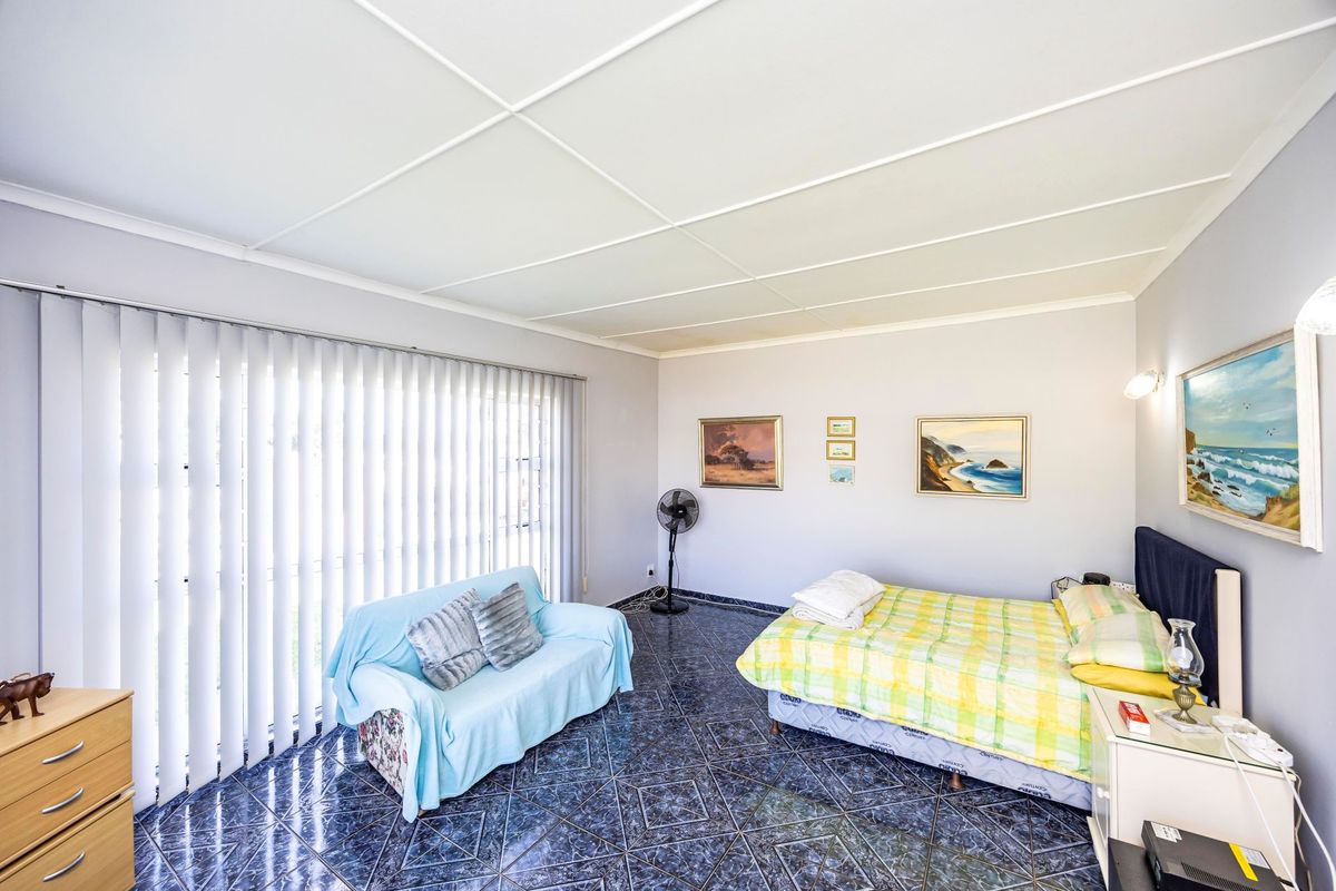 A bedroom featuring tiled flooring, ceiling tiles, and large vertical blinds covering the window.