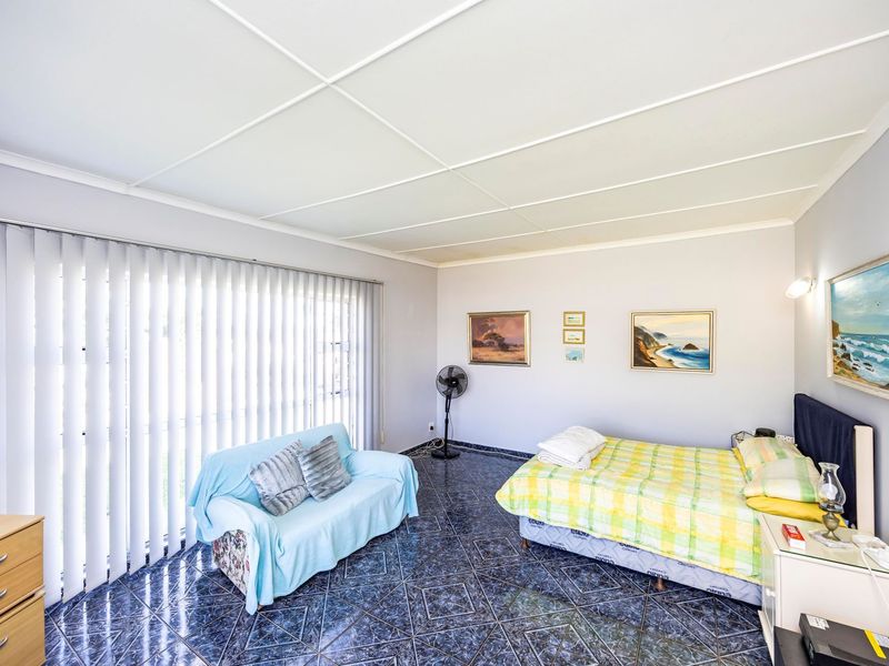 A bedroom featuring tiled flooring, ceiling tiles, and large vertical blinds covering the window.