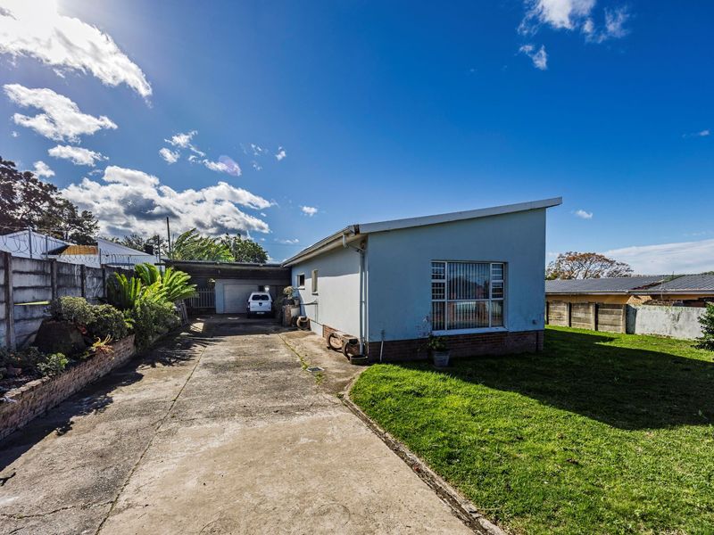 Front exterior view of the property featuring a concrete driveway, single garage, and a fenced yard with a brick and plaster finish.