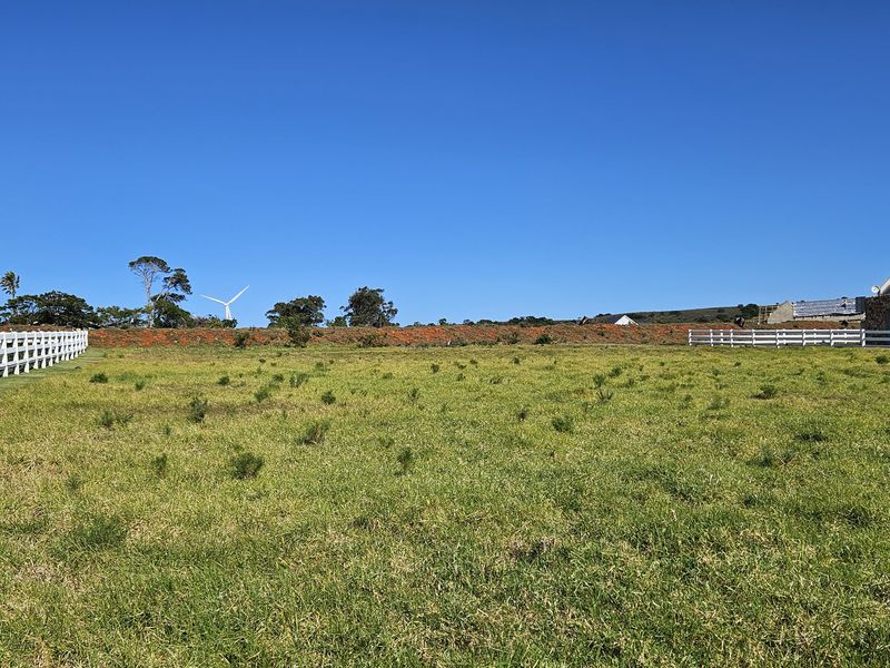 A spacious, level residential vacant land plot featuring established white post and rail perimeter fencing and clear views of the surrounding landscape.