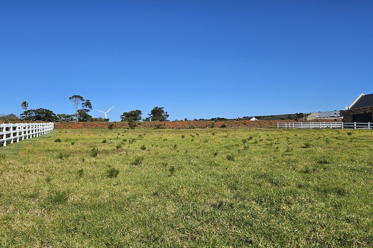 A spacious, level residential vacant land plot featuring established white post and rail perimeter fencing and clear views of the surrounding landscape.