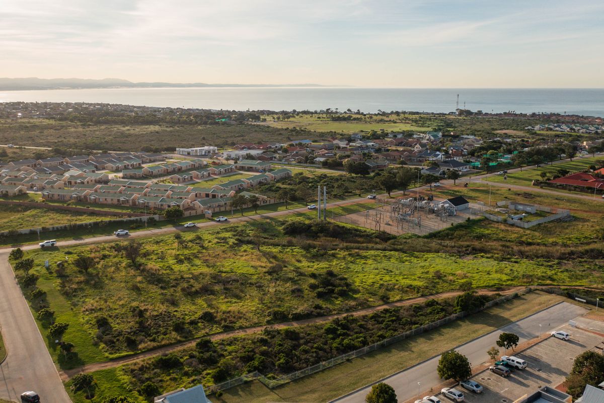 An aerial view of the residential area and surrounding landscape, showcasing the proximity to the coastline and local infrastructure.