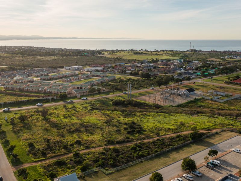 An aerial view of the residential area and surrounding landscape, showcasing the proximity to the coastline and local infrastructure.