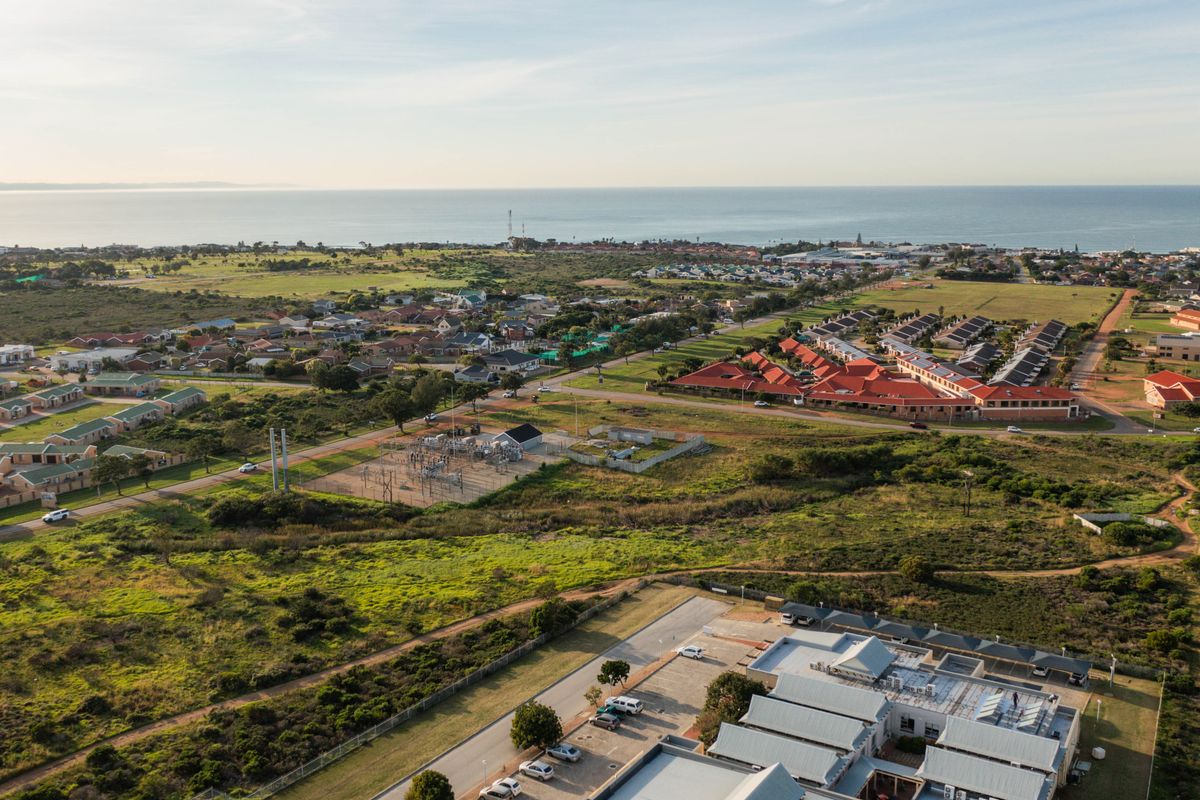 An aerial view of the residential area and surrounding landscape, showcasing the coastal proximity and local infrastructure.