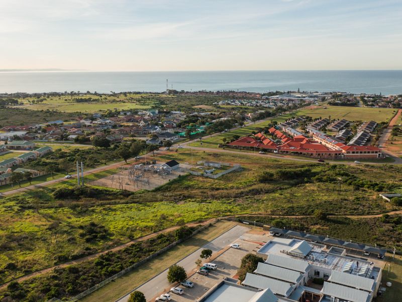 An aerial view of the residential area and surrounding landscape, showcasing the coastal proximity and local infrastructure.