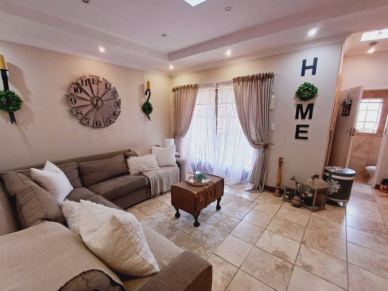 A comfortable living room featuring tiled flooring, recessed ceiling lighting, and sliding glass doors that provide natural light.